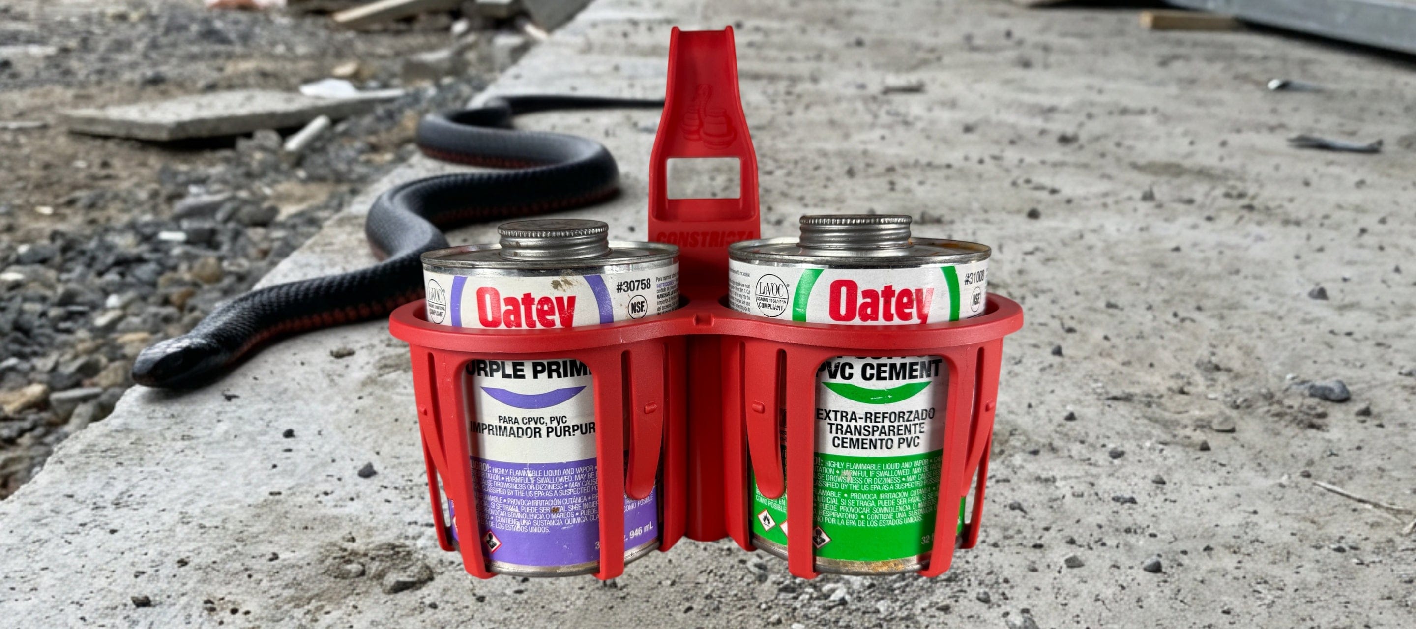 Red Constricta Multi Pot Grip holding PVC glue and primer tins on site.
