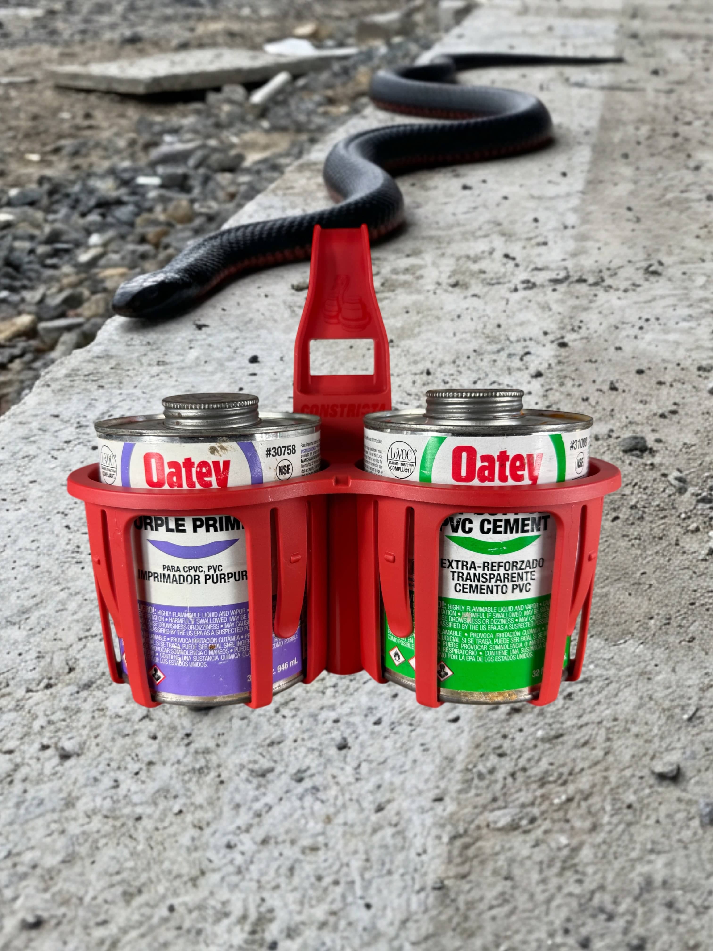 Red Constricta Multi Pot Grip holding PVC glue and primer tins on site.
